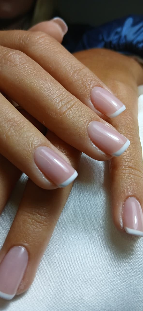 Glossy nude manicure with fine white French tips