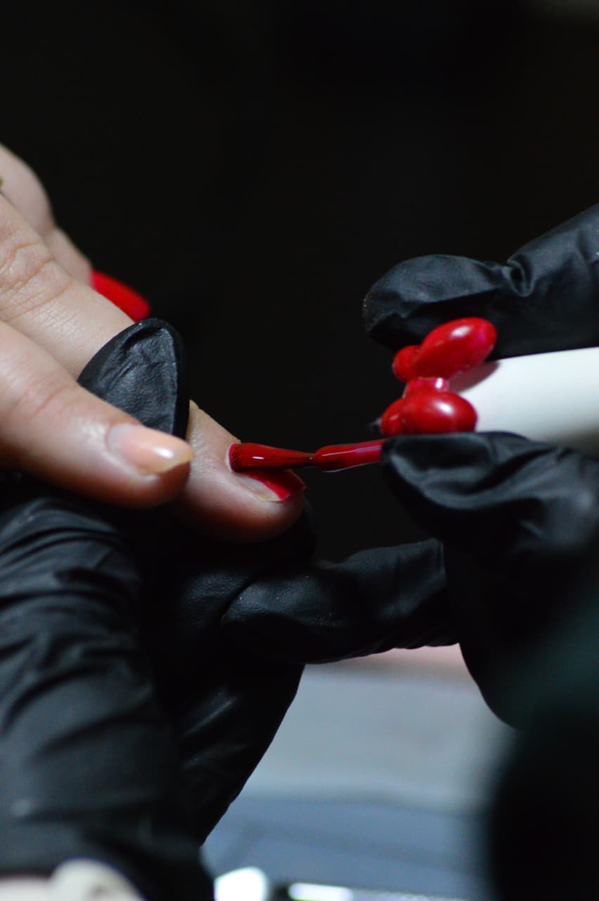 Deep red gel colour being carefully applied